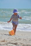 Den gulliga pojken spelar en hink på stranden arkivfoto Den gulliga pojken spelar en hink på stranden arkivfoto