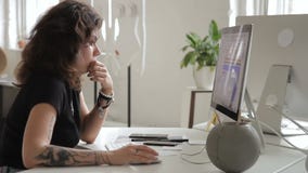 Den informella kvinnan med en tatuering arbetar med en datortabell Den informella kvinnan med en tatuering arbetar med en datortabell