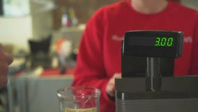 Den kvinnliga ägaren behandlar transaktion på registret Den kvinnliga ägaren behandlar transaktion på registret