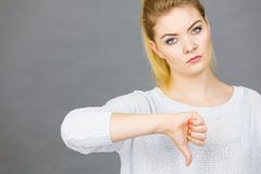 Den ledsna kvinnavisningtummen g?r en gest ner royaltyfri fotografi Den ledsna kvinnavisningtummen g?r en gest ner royaltyfri fotografi