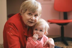 Den lilla söta flickan spelar med den hemmastadda farmodern royaltyfri fotografi Den lilla söta flickan spelar med den hemmastadda farmodern royaltyfri fotografi