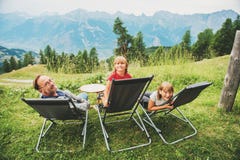 Den lyckliga familjen som fotvandrar i schweiziska fjällängar som tycker om fantastisk sikt, reser med ungar royaltyfria foton Den lyckliga familjen som fotvandrar i schweiziska fjällängar som tycker om fantastisk sikt, reser med ungar royaltyfria foton