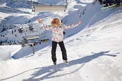 Den lyckliga flickabanhoppningen på berg skidar lutningen royaltyfri fotografi Den lyckliga flickabanhoppningen på berg skidar lutningen royaltyfri fotografi