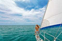 Den lyckliga flickan av seglingyachten har ombord en gyckel arkivfoto Den lyckliga flickan av seglingyachten har ombord en gyckel arkivfoto