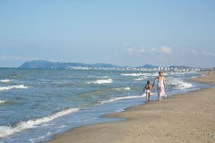 Den lyckliga härliga mamman och barnet som promenerar havet, sätter på land, kopia-utrymme Royaltyfri Bild Den lyckliga härliga mamman och barnet som promenerar havet, sätter på land, kopia-utrymme Royaltyfri Bild