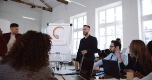 Den lyckliga le Caucasian mitt åldrades lagledareaffärsmannen som leder det multietniska partnermötet som diskuterar arbete på ko arkivfilmer Den lyckliga le Caucasian mitt åldrades lagledareaffärsmannen som leder det multietniska partnermötet som diskuterar arbete på ko arkivfilmer