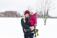 Den lyckliga unga modern med ett barn på en vinter går royaltyfria bilder Den lyckliga unga modern med ett barn på en vinter går royaltyfria bilder