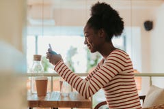 Den låga vinkeln av lyckliga afrikanska kvinnan som den har, vilar i kafé fotografering för bildbyråer Den låga vinkeln av lyckliga afrikanska kvinnan som den har, vilar i kafé fotografering för bildbyråer