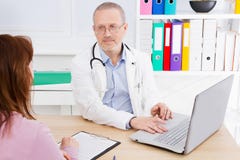 Den manliga doktorn talar till den kvinnliga patienten i sjukhuskontor Sjukvård och medicinsk service hjälpande folk arkivfoton Den manliga doktorn talar till den kvinnliga patienten i sjukhuskontor Sjukvård och medicinsk service hjälpande folk arkivfoton