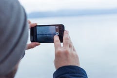 den manliga fotvandraren tar en bild med telefonen royaltyfria foton den manliga fotvandraren tar en bild med telefonen royaltyfria foton