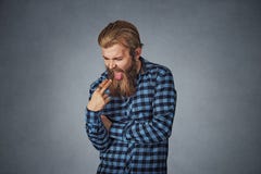 Den misshog äcklade mannen med fingret i mun önskar att kasta upp royaltyfria bilder Den misshog äcklade mannen med fingret i mun önskar att kasta upp royaltyfria bilder