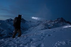 Den modiga handelsresandemannen begår skidar turnerar på det höga berget på natten Den yrkesmässiga snowboarderen tänder vägen me arkivbilder Den modiga handelsresandemannen begår skidar turnerar på det höga berget på natten Den yrkesmässiga snowboarderen tänder vägen me arkivbilder