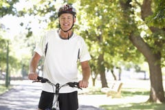 Den mogna mannen som cyklar parkerar igenom royaltyfria bilder Den mogna mannen som cyklar parkerar igenom royaltyfria bilder