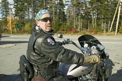 Den motorcykelHarley chauffören ser in i kameran, Acadianationalparken, Maine royaltyfri foto Den motorcykelHarley chauffören ser in i kameran, Acadianationalparken, Maine royaltyfri foto