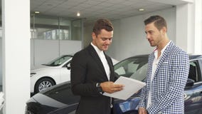 Den potentiella köparen och säljaren läste kännetecknen av bilen royaltyfria foton Den potentiella köparen och säljaren läste kännetecknen av bilen royaltyfria foton