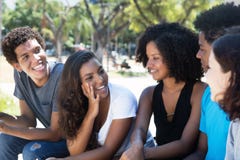 Den senare kvinnan och afrikanen man samtal med caucasian vänner fotografering för bildbyråer Den senare kvinnan och afrikanen man samtal med caucasian vänner fotografering för bildbyråer