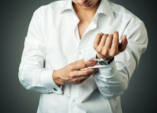 Den sexiga mannen knäppas manschettknappen på franska manschetter arkivfoton Den sexiga mannen knäppas manschettknappen på franska manschetter arkivfoton