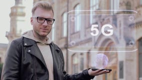 Den smarta unga mannen med exponeringsglas visar ett begreppsmässigt hologram 5G lager videofilmer Den smarta unga mannen med exponeringsglas visar ett begreppsmässigt hologram 5G lager videofilmer