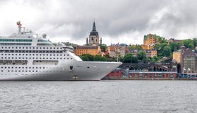 Den stora vita kryssningeyeliner är på pir mot stadslinjen, Stockholm, Sverige royaltyfri bild Den stora vita kryssningeyeliner är på pir mot stadslinjen, Stockholm, Sverige royaltyfri bild