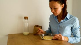 Den unga kvinnan som ?ter cornflakes med, mj?lkar f?r frukost i k?k p? morgonen stock video Den unga kvinnan som ?ter cornflakes med, mj?lkar f?r frukost i k?k p? morgonen stock video