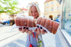 Den unga kvinnliga turisten med den traditionella tjeckiska efterrätten kallade trdelnik Prague royaltyfria foton Den unga kvinnliga turisten med den traditionella tjeckiska efterrätten kallade trdelnik Prague royaltyfria foton