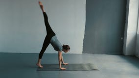Den unga kvinnlign utför en backflip med händer i den rymliga balsalen Böjlig kvinna som gör splittringar i studio arkivfilmer Den unga kvinnlign utför en backflip med händer i den rymliga balsalen Böjlig kvinna som gör splittringar i studio arkivfilmer