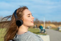 Den unga lyckliga rödhåriga mannen som flickan i parkerar på våren nära floden, lyssnar till musik till och med trådlös bluetooth royaltyfri bild Den unga lyckliga rödhåriga mannen som flickan i parkerar på våren nära floden, lyssnar till musik till och med trådlös bluetooth royaltyfri bild