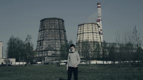 Den unga pojken går i framdel av fabrikslampglas f?rorening f?r fabrik f?r luftbakgrund bl? Nära övre stående av den unga grabbwi arkivfilmer Den unga pojken går i framdel av fabrikslampglas f?rorening f?r fabrik f?r luftbakgrund bl? Nära övre stående av den unga grabbwi arkivfilmer