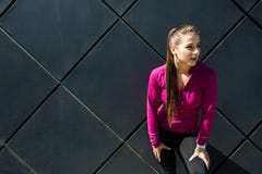 Den unga sportiga flickan som bär den rosa sportswearen, kopplar av efter utarbetande utomhus- utbildning, känslig frihet och kop royaltyfri bild Den unga sportiga flickan som bär den rosa sportswearen, kopplar av efter utarbetande utomhus- utbildning, känslig frihet och kop royaltyfri bild
