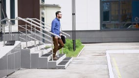 Den unga stiliga skäggiga mannen i blå skjorta och brun byxa går utanför Student som utomhus lyckligt after går stock video Den unga stiliga skäggiga mannen i blå skjorta och brun byxa går utanför Student som utomhus lyckligt after går stock video