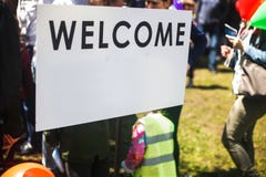 Den vita välkomnandet undertecknar i gatan Suddigt folk som besöker en händelse i staden royaltyfri bild Den vita välkomnandet undertecknar i gatan Suddigt folk som besöker en händelse i staden royaltyfri bild