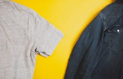 Denimjacke und graues T-Shirt auf zwei Seiten des Fotos, auf gelbem Hintergrund, mit copyspace lizenzfreie stockbilder Denimjacke und graues T-Shirt auf zwei Seiten des Fotos, auf gelbem Hintergrund, mit copyspace lizenzfreie stockbilder