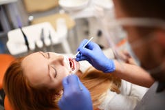 Dentist starting common operation of cleaning female mouth royalty free stock photo Dentist starting common operation of cleaning female mouth royalty free stock photo