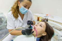 Dentista de la hembra adulta que trata los dientes pacientes de la mujer Concepto de la medicina, de la odontología y de la atenc foto de archivo Dentista de la hembra adulta que trata los dientes pacientes de la mujer Concepto de la medicina, de la odontología y de la atenc foto de archivo