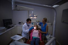 Dentista que examina a un paciente joven con las herramientas imágenes de archivo libres de regalías Dentista que examina a un paciente joven con las herramientas imágenes de archivo libres de regalías
