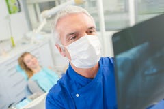 Dentista que olha o raio X fotografia de stock Dentista que olha o raio X fotografia de stock