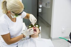 Dentista que usa un laser dental del diodo moderno fotos de archivo libres de regalías Dentista que usa un laser dental del diodo moderno fotos de archivo libres de regalías