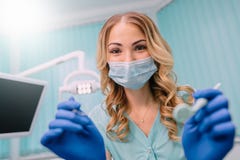 Dentiste féminin plié au-dessus du patient pour examiner images stock Dentiste féminin plié au-dessus du patient pour examiner images stock