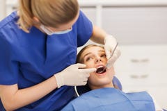 Dentiste féminin vérifiant les dents patientes de fille images stock Dentiste féminin vérifiant les dents patientes de fille images stock