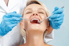 Dentysta egzamininuje pacjenta zęby w dentis zdjęcie stock Dentysta egzamininuje pacjenta zęby w dentis zdjęcie stock