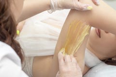 Depilation ζάχαρης τα shugaring χέρια κάνουν το κορίτσι στο κέντρο SPA στοκ εικόνες με δικαίωμα ελεύθερης χρήσης Depilation ζάχαρης τα shugaring χέρια κάνουν το κορίτσι στο κέντρο SPA στοκ εικόνες με δικαίωμα ελεύθερης χρήσης