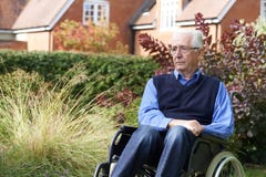 Depressed Senior Man Sitting Outdoors In Wheelchair royalty free stock photography Depressed Senior Man Sitting Outdoors In Wheelchair royalty free stock photography