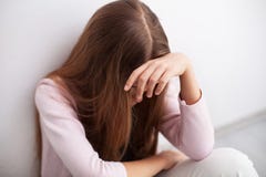 Depressie in adolescentie - de jonge zitting van het tienermeisje door muur stock foto Depressie in adolescentie - de jonge zitting van het tienermeisje door muur stock foto