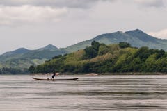 Der Fischer, der auf dem Boot balanciert wird, startet das Netz auf dem Mekong, Luang Prabang, Laos stockfoto Der Fischer, der auf dem Boot balanciert wird, startet das Netz auf dem Mekong, Luang Prabang, Laos stockfoto