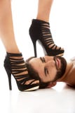 Der Fuß der Frau auf dem Gesicht des Mannes Lizenzfreies Stockbild Der Fuß der Frau auf dem Gesicht des Mannes Lizenzfreies Stockbild
