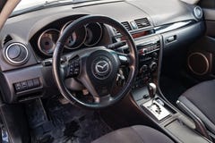 Der Innenraum des Autos Mazda 3 mit Blick auf das Lenkrad-, Armaturenbrett-, Sitz- und Multimediasystem mit hellgrauer Ordnung un stockfotos Der Innenraum des Autos Mazda 3 mit Blick auf das Lenkrad-, Armaturenbrett-, Sitz- und Multimediasystem mit hellgrauer Ordnung un stockfotos