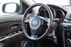 Der Innenraum des Autos Mazda 3 mit Blick auf das Lenkrad-, Armaturenbrett-, Sitz- und Multimediasystem mit hellgrauer Ordnung un stockfotografie Der Innenraum des Autos Mazda 3 mit Blick auf das Lenkrad-, Armaturenbrett-, Sitz- und Multimediasystem mit hellgrauer Ordnung un stockfotografie