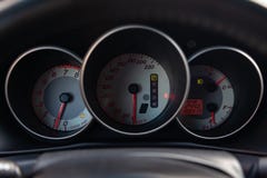 Der Innenraum des Autos mit Blick auf den Armaturenbrett, den Geschwindigkeitsmesser und den Tachometer mit hellgrauer Ordnung stockfoto Der Innenraum des Autos mit Blick auf den Armaturenbrett, den Geschwindigkeitsmesser und den Tachometer mit hellgrauer Ordnung stockfoto