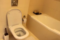 Der Innenraum des Badezimmers eine Toilettenschüssel und eine Badewanne stockbild Der Innenraum des Badezimmers eine Toilettenschüssel und eine Badewanne stockbild