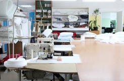Der Innenraum des nähenden Fabrikgeschäftes Geschlossenes Studio mit einigen Nähmaschinen Textilindustrie Unscharfes Foto für bac lizenzfreies stockbild Der Innenraum des nähenden Fabrikgeschäftes Geschlossenes Studio mit einigen Nähmaschinen Textilindustrie Unscharfes Foto für bac lizenzfreies stockbild